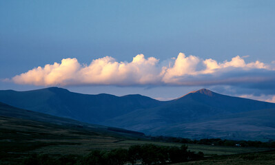 Fototapeta premium a natural landscape showcasing a sky that graduates from deep blue at the top to a lighter hue, then a horizontal formation of clouds