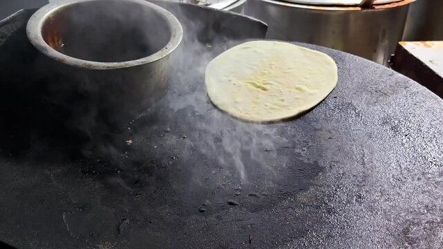 Indian aloo paratha cooking on a hot tawa