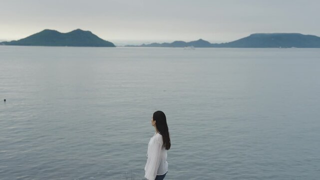 夕暮れの海にいる女性