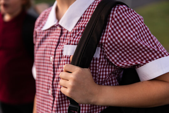 close up of a school student holding a bag strap over a shoulder