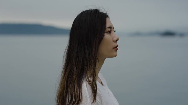 夕暮れの海にいる女性