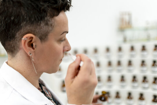 Female perfumer smelling a fragrance blotter strip