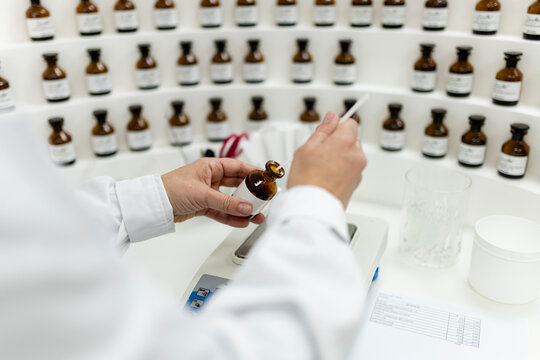 Hands of perfumer creating fragrance in laboratory