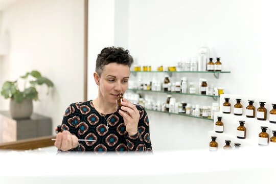 Female perfumer smelling scents in her workshop