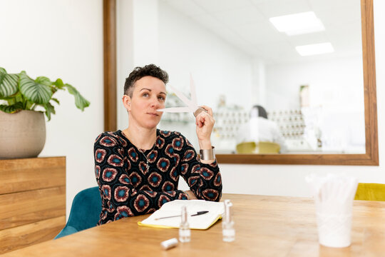 Woman with short hair smelling perfume test strips