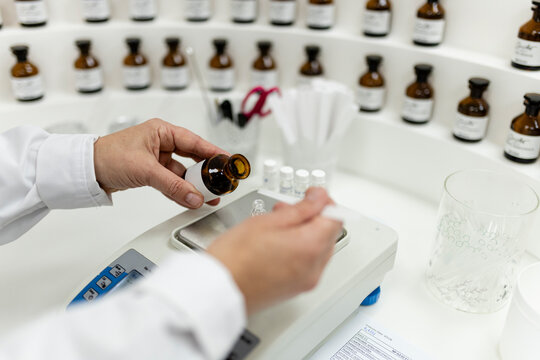 Perfumer carefully measuring fragrance oil in a lab