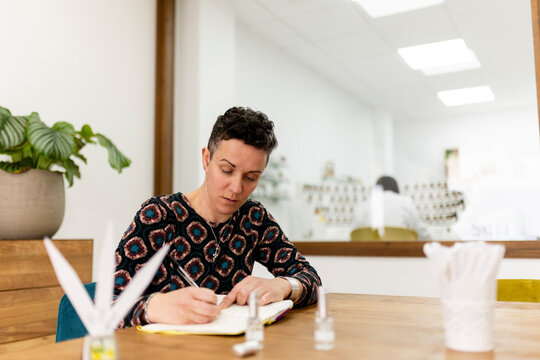 Perfumer writing notes while creating a new scent