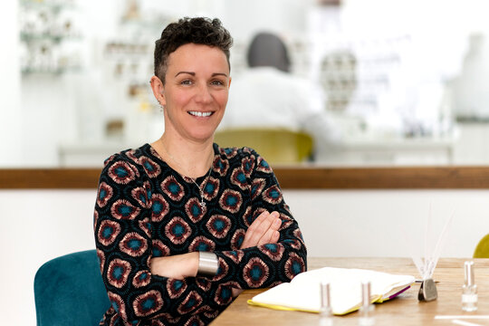 Confident female perfumer smiling in her workshop