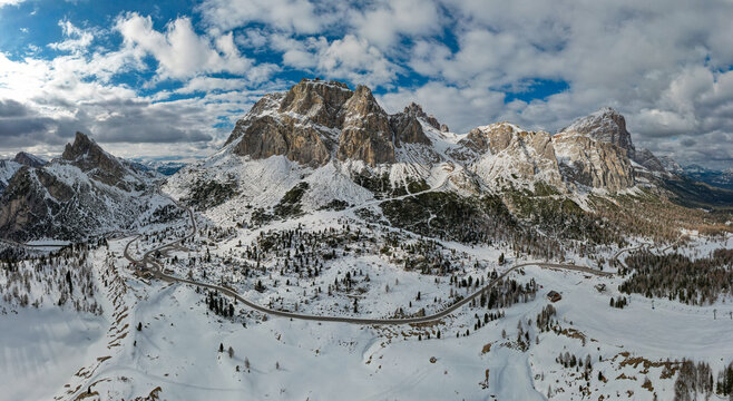 Panoramic View of Falzarego Pass with Snowy Peaks and Winding Road, Dolomites, Italy