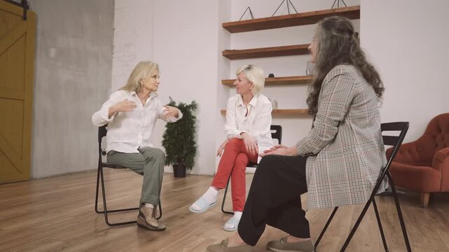 Three ladies chatting and gossiping in room, women community for communication. Senior female persons discussing problems of old age, how to stay beautiful, active and healthy after 60 years old