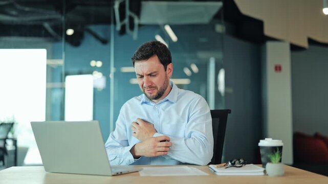 Corporate manager or IT specialist suffering from allergy, skin irritation, itch or red rash at laptop. Tired employee or freelance worker scratching hand due to dermatitis during office work
