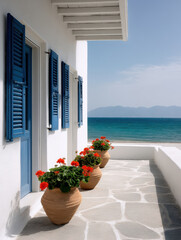 Obraz premium Island villa facade blue shutter white wall sea view stone terrace flower pot, sunny coastal walkway with red geranium, calm summer mood