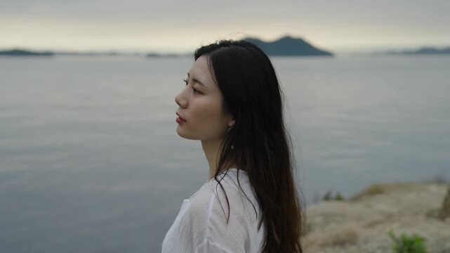 夕暮れの海にいる女性