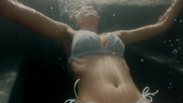 Woman submerged in a cold plunge ice bath outdoors