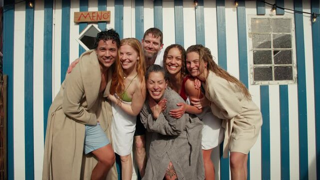 Friends in bathrobe laughing together outside a spa retreat cabin