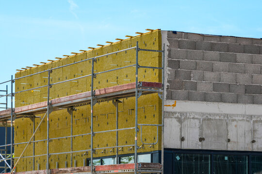 Mineral wool facade insulation installation on commercial building under construction project site