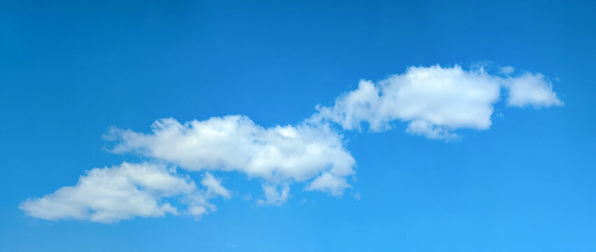 A small long clouds moves across the clear blue sky. The path of the rain is from left to right.. White hat cloud dreaming in your imagination