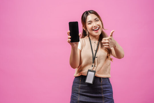 Happy young Asian woman is showing thumbs up gesture while presenting copy space on her phone.