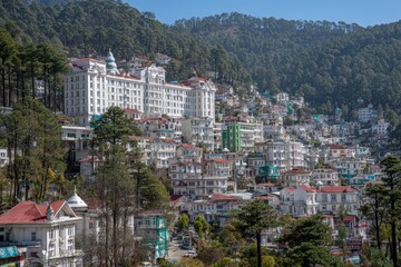 Fototapeta premium Majestic white building overlooks a hillside town with colorful structures