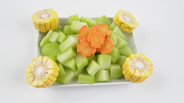 Vegetable Package with Chayote, Corn and Carrots on Plate Isolated on White Background for Fresh Cooking Ingredient Concepts