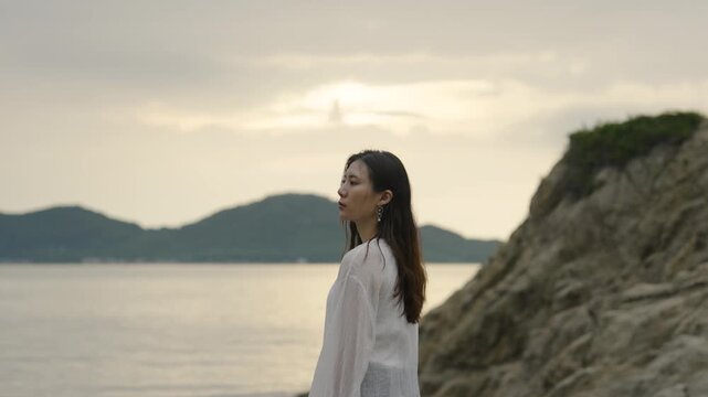 夕暮れの海にいる女性