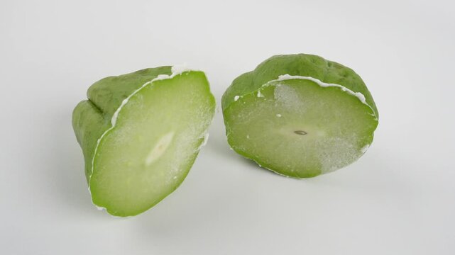 Chayote Cut in Half with White Sap Isolated on White Background for Fresh Vegetable Preparation Concepts