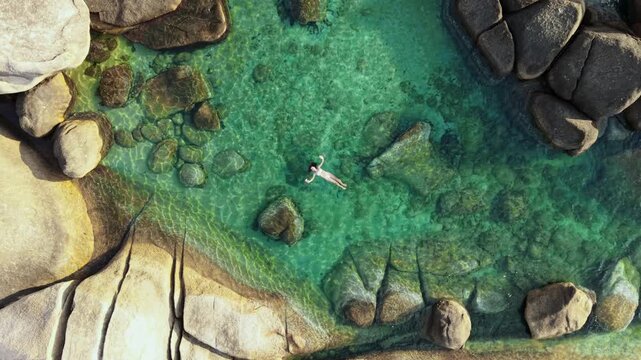 Aerial Top Down View of Woman Swimming in Natural Granite Rock Pool Ko Samui Thailand