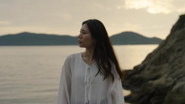 夕暮れの海にいる女性
