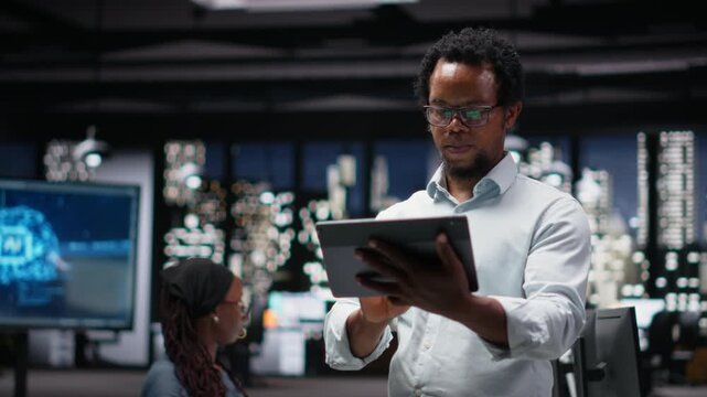 Programmer in office developing app using tablet, writing code. Silicon Valley startup employee using device to troubleshoot software glitches, resolving system crashes for coding workflows.