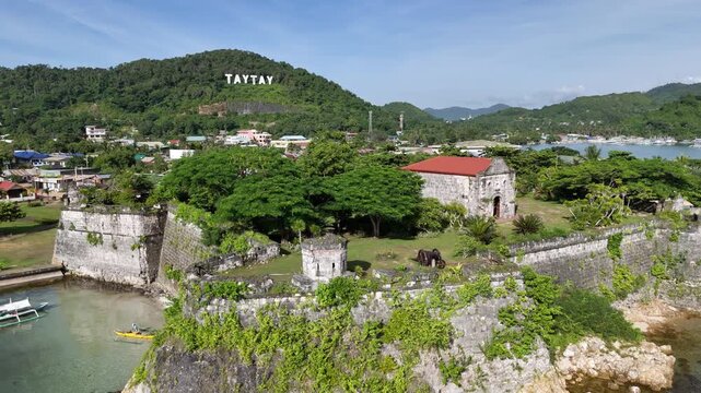 Pull-away riser drone shot revealing Fort Santa Isabel in Taytay, Palawan. The aerial view showcases the coral stone walls, historic cannons, and colonial architecture