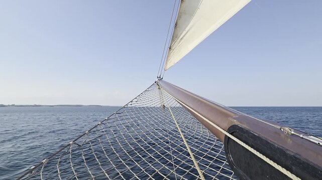 Classic Sailing Ship Bowsprit and Headsail Cutting Through Open Sea - Deck View