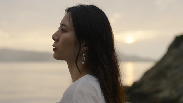 夕暮れの海にいる女性