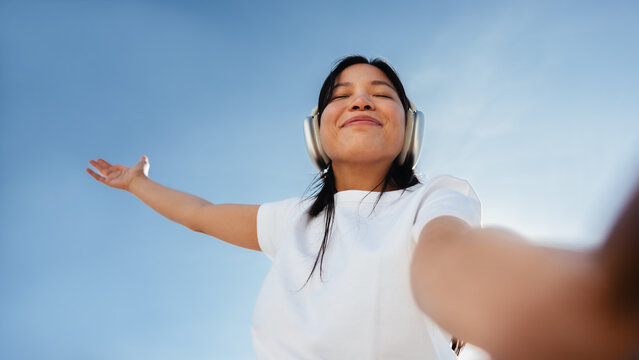 Woman enjoying music and joy outdoors with headphones