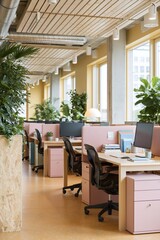 Fototapeta premium Contemporary open plan office with pink workstations plants and exposed ductwork for collaborative workspace background and interior design
