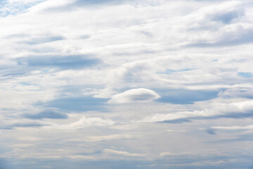Obraz premium Beautiful white layered clouds on a soft blue sky background. Ethereal atmospheric texture for nature, travel, and religious commercial projects