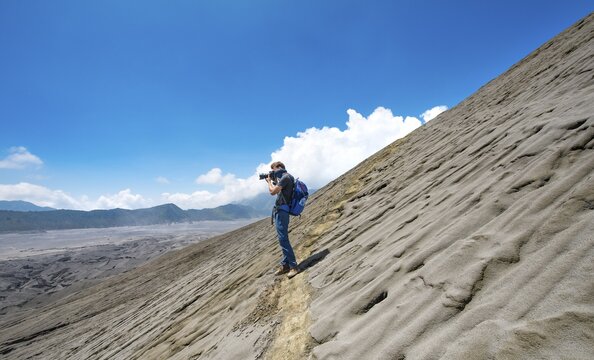 Narrow path at the crater rim, young man photographed, crater of the volcano Gunung Bromo, National Park Bromo-Tengger-Semeru, Java, Indonesia