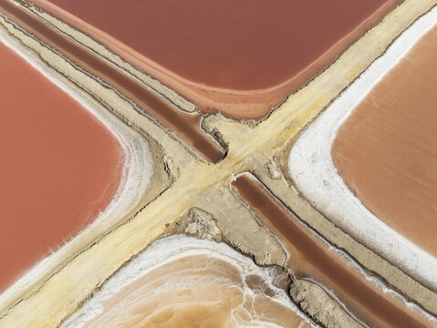 Saline ponds at the Bonanza salt works near Sanl&uacute;car de Barrameda. The reddish colour depends on the level of salinity and is directly caused by the algae Dunaliella salina and brine shrimp. Aerial view. Drone shot. C&aacute;diz province, Andalusia, Spain
