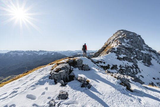 Climbers on the rocky summit ridge with first snow in autumn, hiking trail to Guffert, solar reflex, Brandenberg Alps, Tyrol, Austria