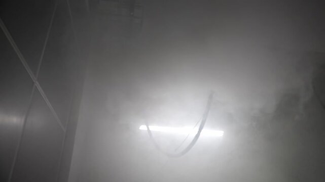 Fog filling an interior space during a climate system test, creating a dense, atmospheric vapor transition for visual effects and environmental simulation.