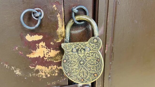 Vintage ornate padlock with oriental patterns on an old weathered wooden door in Istanbul. Ancient metal lock closing an antique entrance in Turkey. Perfect for history and mystery concepts.