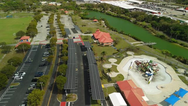Aerial approach toward solar panel parking canopies in Lauderhill park