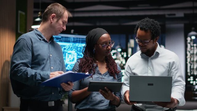 Engineering team in office developing machine learning algorithms simulating human brain thought processes. Teamworking colleagues deploy AI tools, performing software quality assurance.