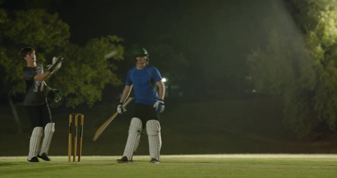 Under floodlight after bowler run male batsman missing ball two times then connecting swing