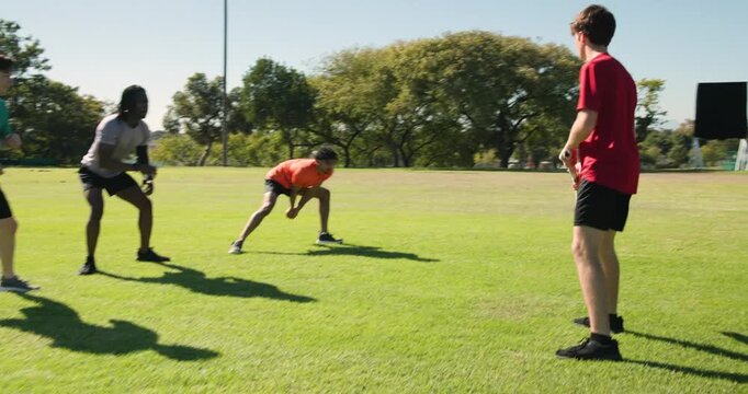 Diverse athletes training cricket at park, batsman bouncing red ball, swinging bat