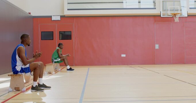 After rebound, dribbling past defender, african american man #4 shooting, school gym, copy space