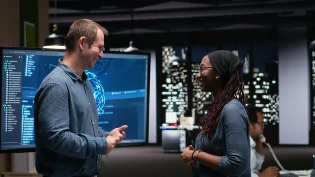 Silicon Valley company IT staff members laughing in office, developing apps with AI. System administrators sharing jokes while waiting for artificial intelligence to debug applications.