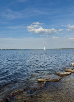 Shore at Senftenberg Lake with 
sailboat in Brandenburg tourism vacation region in Germany vertical