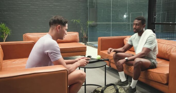 Diverse male friends entering athletic lounge pulling paddle, balls preparing ping pong game