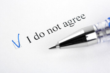 Obraz premium A close-up view of a document with a blue ink check mark next to the phrase I do not agree, alongside a pen. Concept of disagreement, refusal, cookies policy rejection, or legal dissent.