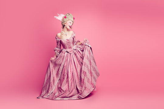 Photo of pretty gorgeous court lady in medieval castle dancing wearing antique style dress isolated pink color background